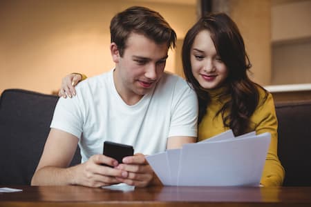 Pareja mirando documentos en el teléfono